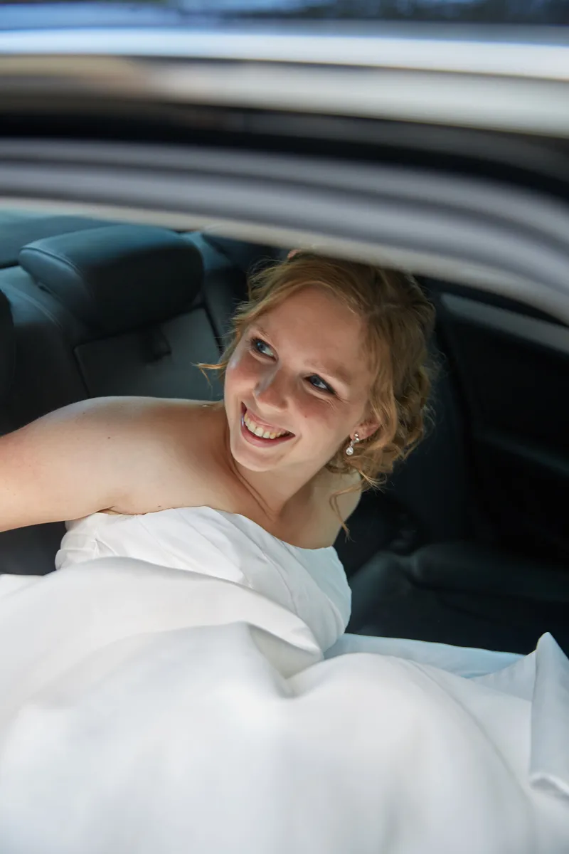 Linsey lacht vanaf de achterbank van de auto
