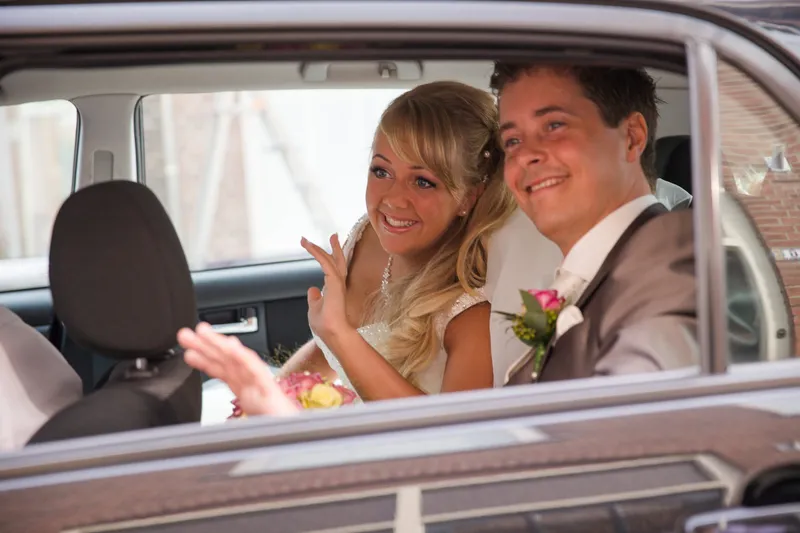 Linda en Alex zwaaien vanuit de auto