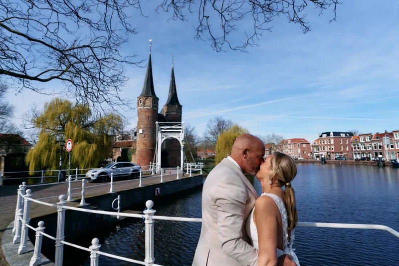 Danitsja en Brian kussen bij het water, de torens van de Oostpoort erachter