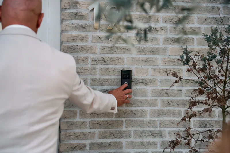 Brian belt aan bij de voordeur, in zijn crèmekleurige pak