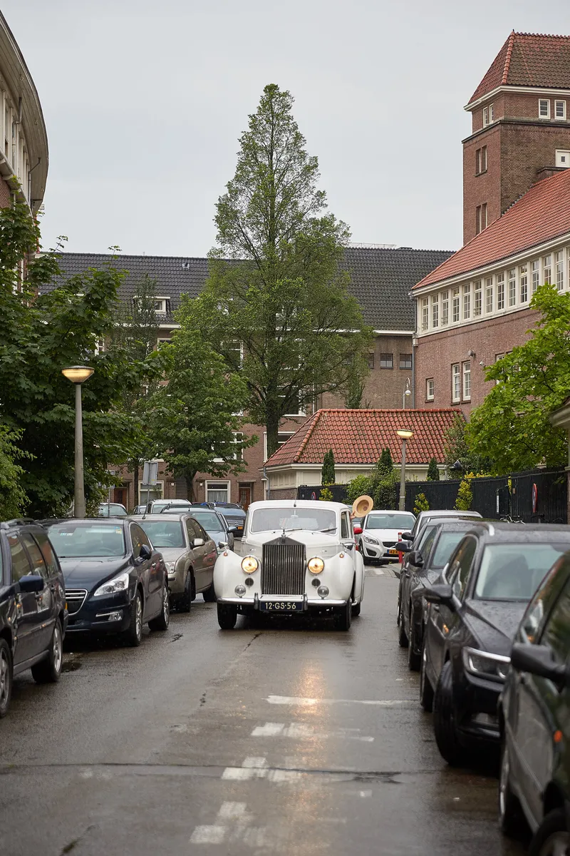 De witte Rolls-Royce in een natte Amsterdamse straat