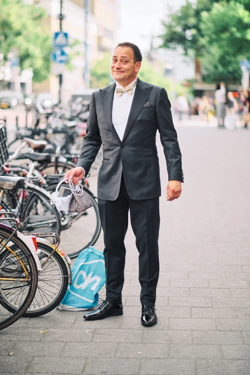 Wilfried wacht op straat in zijn pak