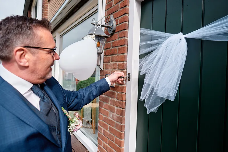 Jakob belt aan bij de deur met ballon en tule