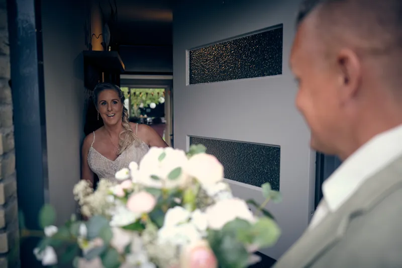 Tamara opent de deur, Marco staat klaar met het boeket