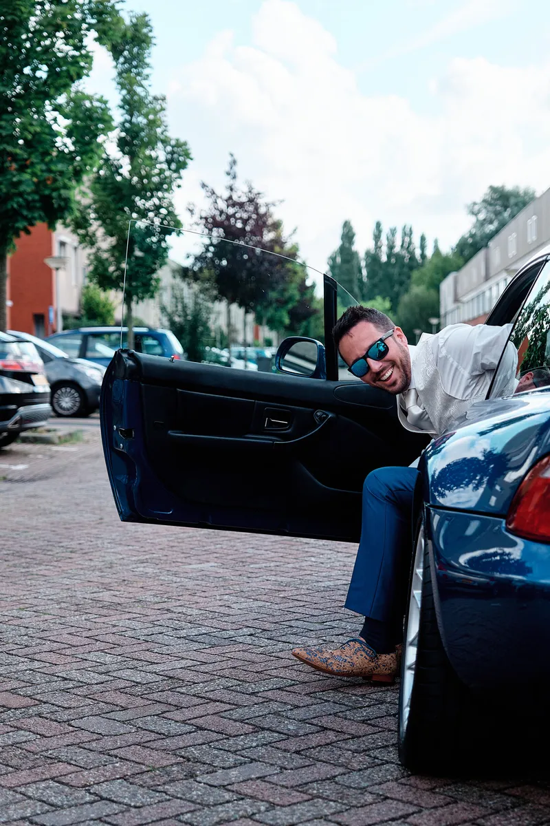 Jeroen stapt uit de blauwe BMW