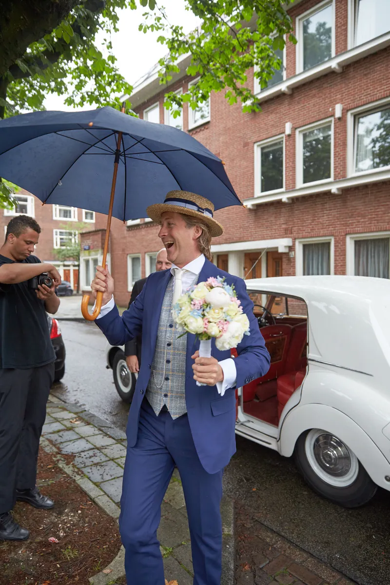 Wouter met paraplu en boeket bij de Rolls-Royce