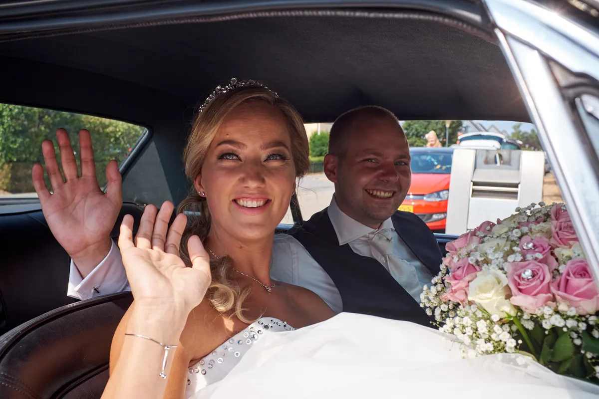 Marcella en Kevin zwaaien vanuit de auto
