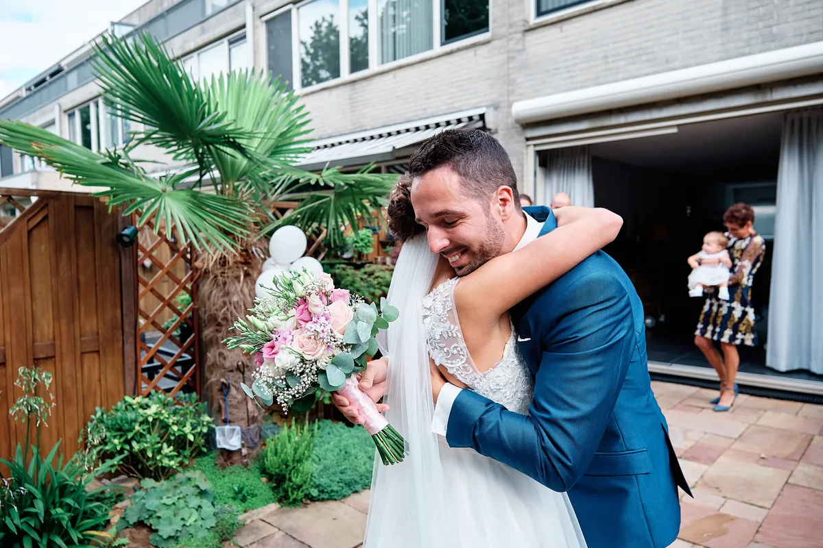 Jeroen omhelst Tessa in de tuin van haar ouders