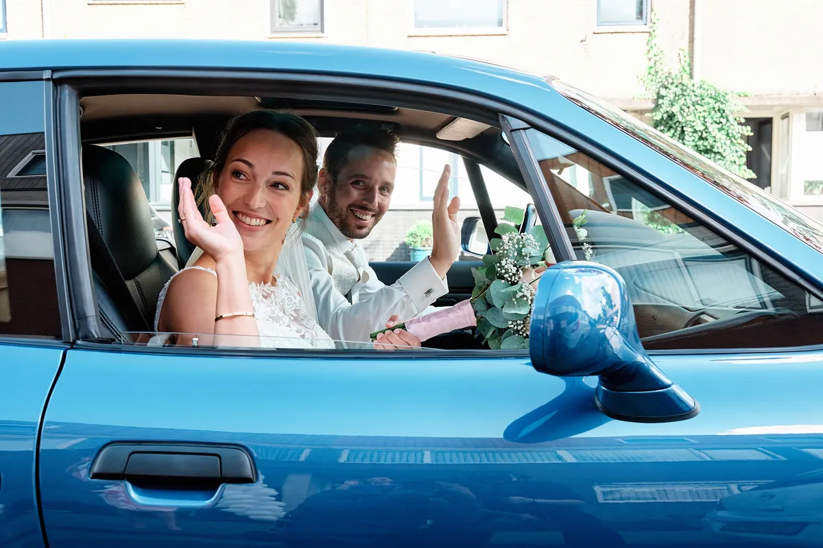 Tessa en Jeroen zwaaien vanuit de auto