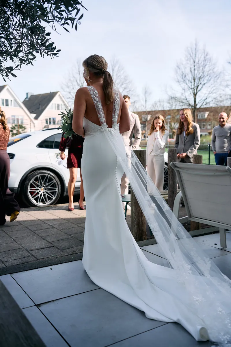 Danitsja loopt met haar sleep over de stoep naar de auto