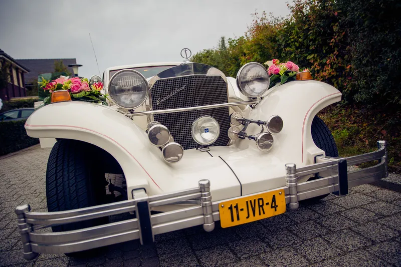 De witte oldtimer met bloemen op de motorkap