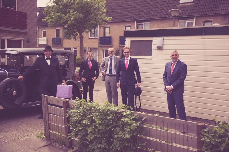De vrienden in pak wachten buiten