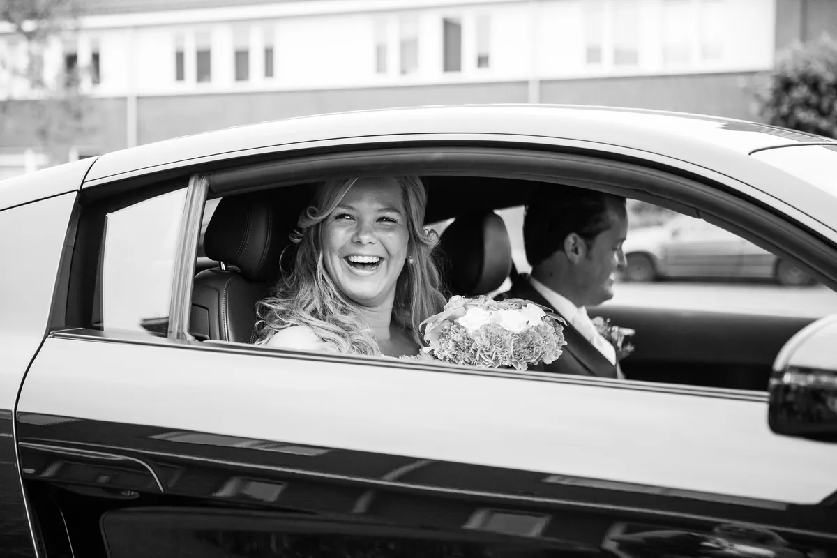 Esther en Jan-Willem lachen door het raam van de Audi R8, in zwart-wit
