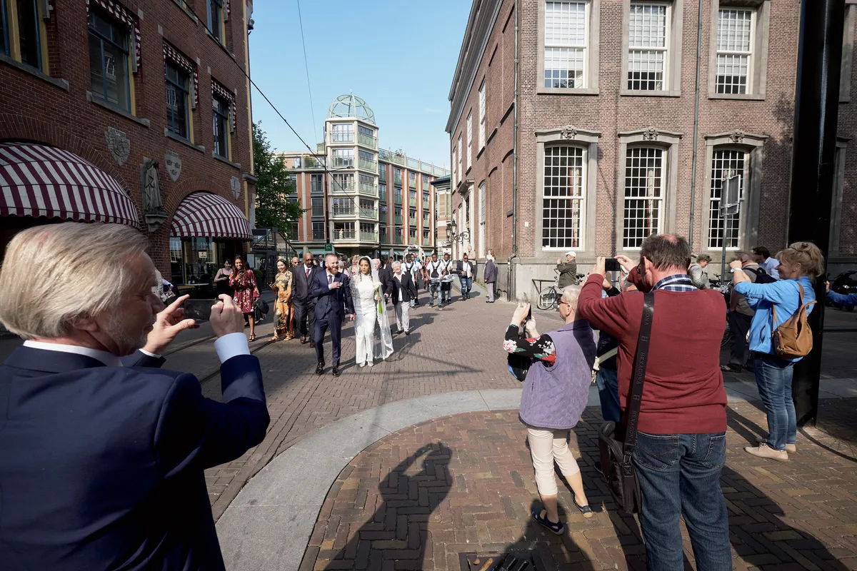 Gasten fotograferen het bruidspaar op straat