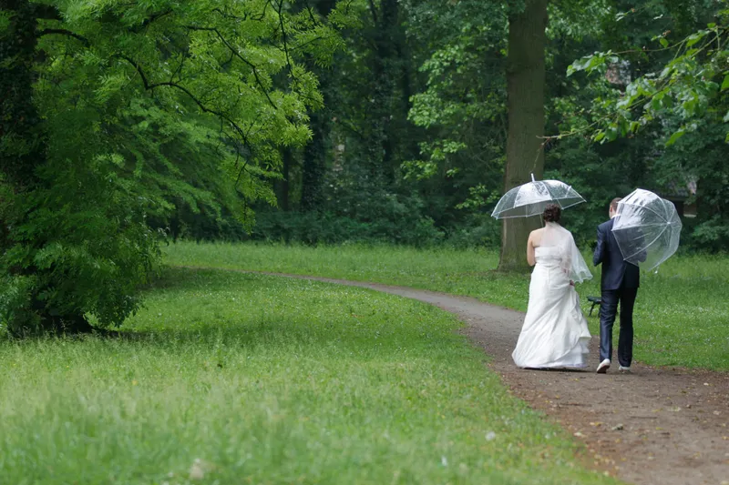 Tessa en Wessel onder hun paraplu’s op het grasveld