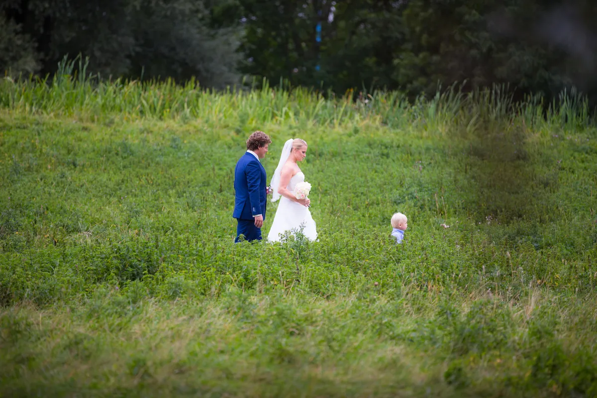 Liselotte en Matthijs met hun zoontje in het hoge gras