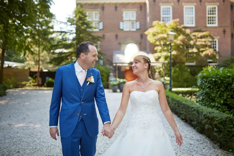 Herman en Margherita lopen hand in hand over het pad bij het kasteel