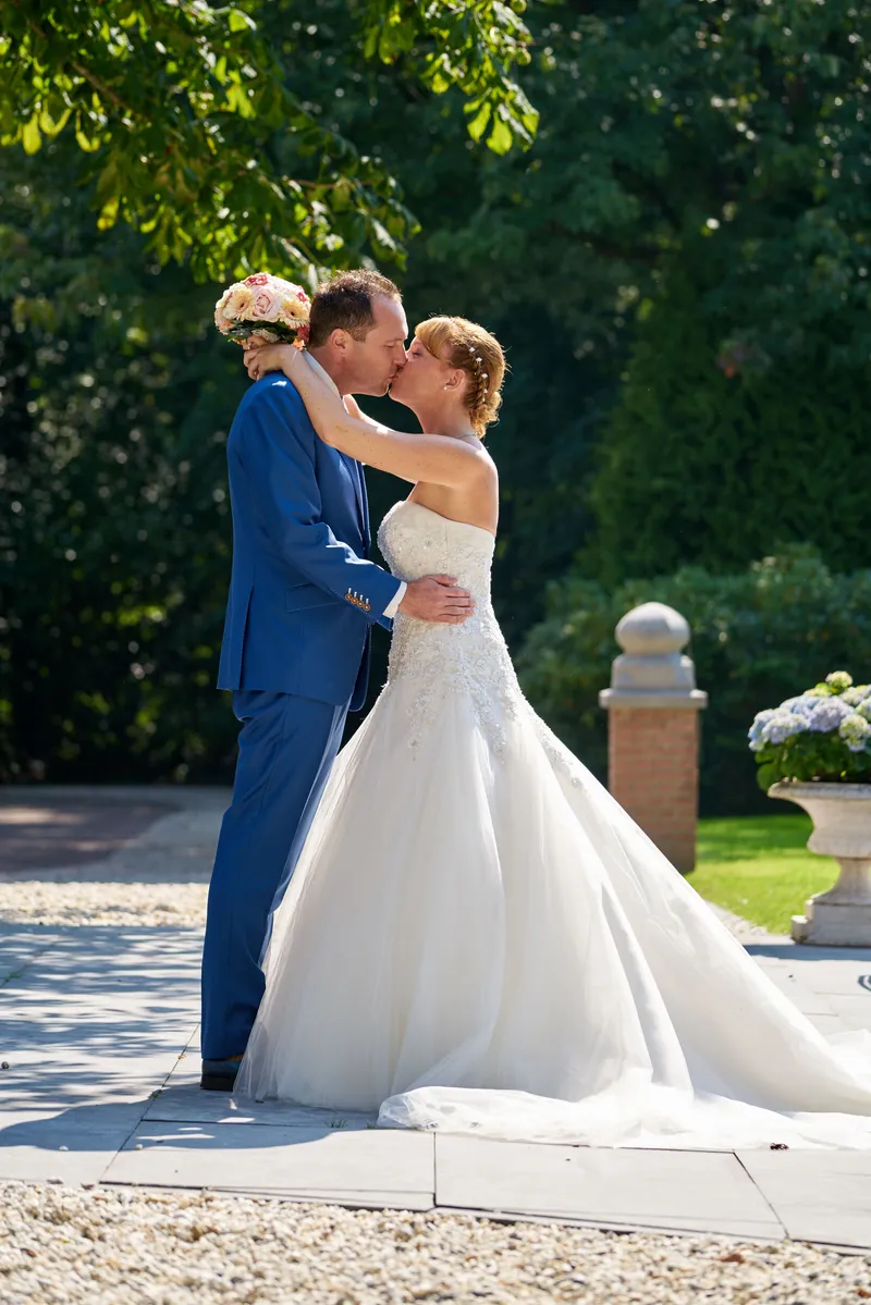 Herman en Margherita kussen bij een stenen vaas in de tuin
