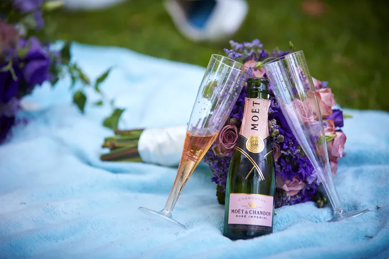 Champagne en de boeketten op een deken