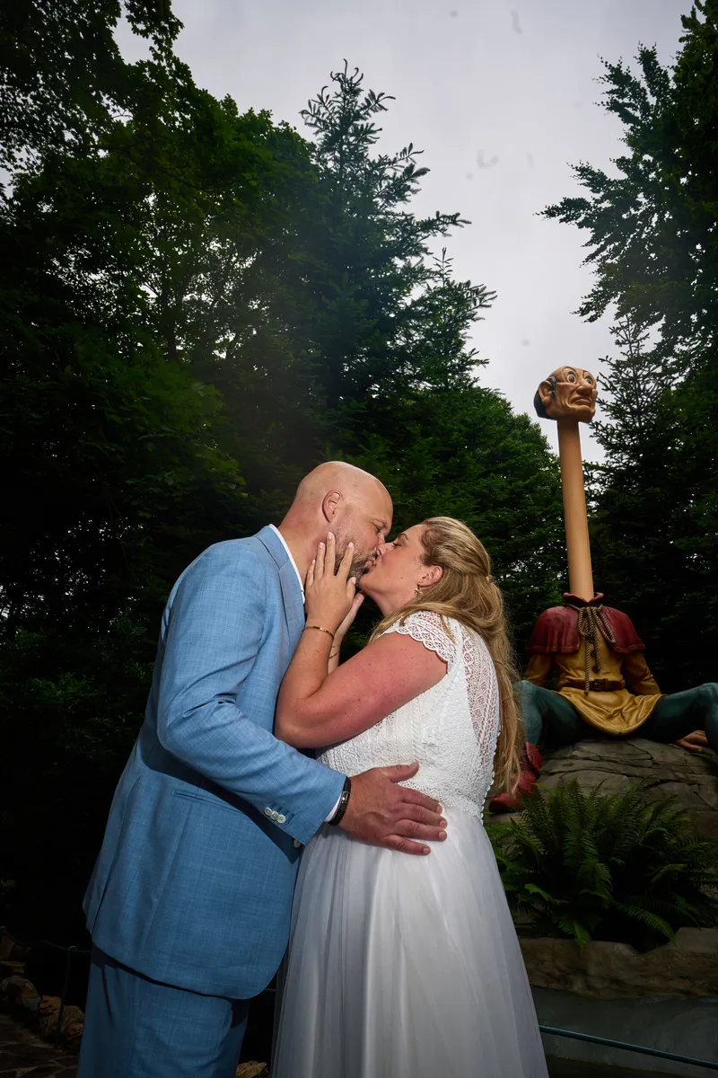 Annemarie en Jan kussen elkaar in het bos, met de Langnek erachter