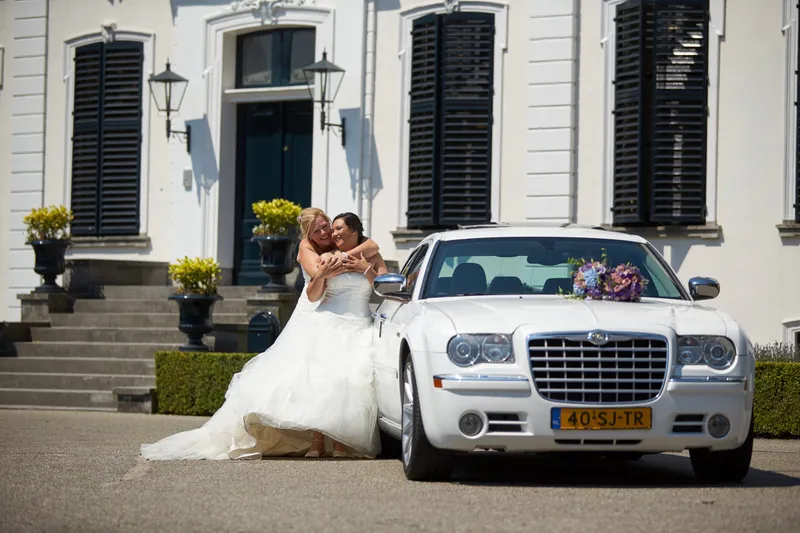 Prunella en Cora bij de witte auto voor een wit landhuis