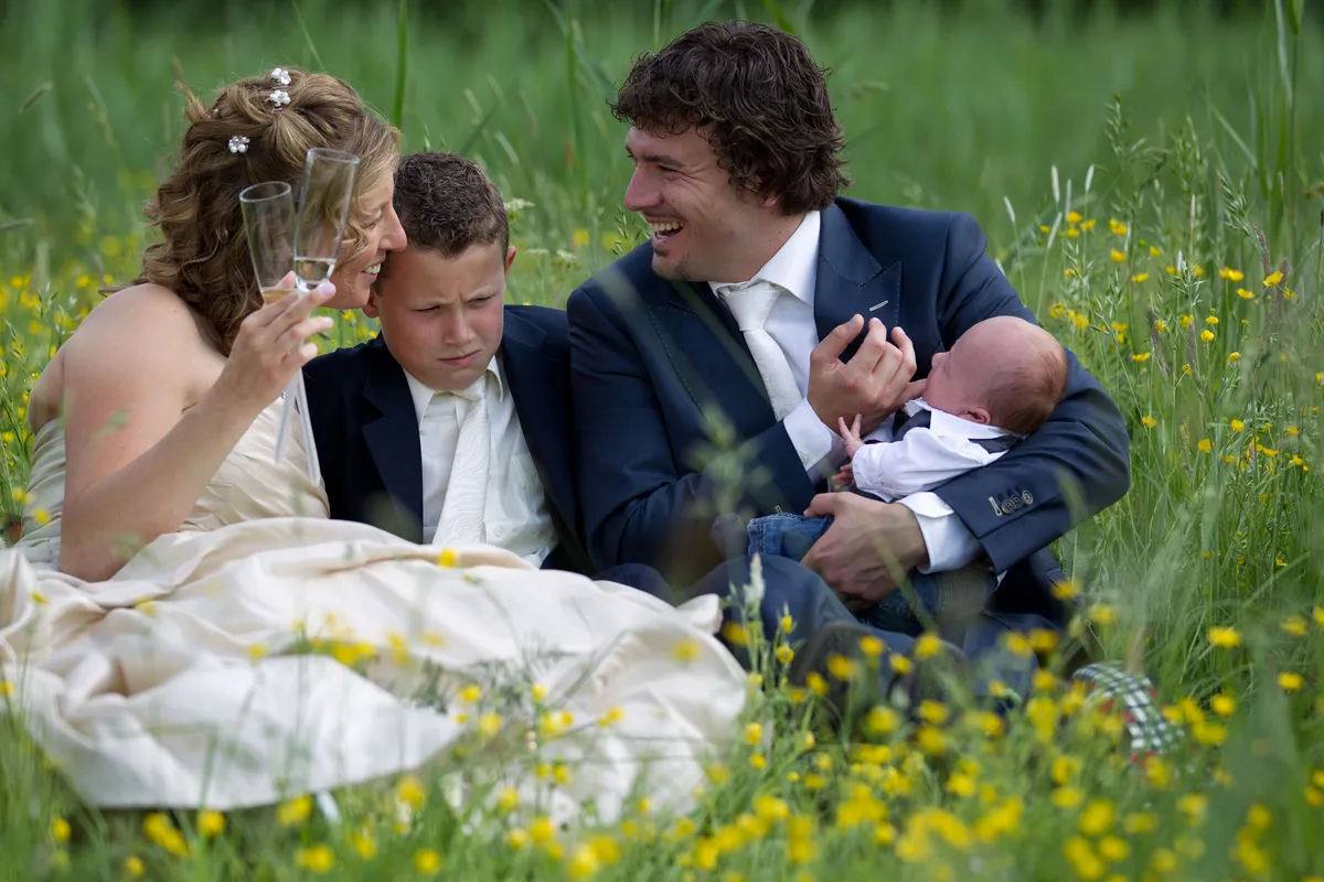 Patricia en Arno met hun zoon en hun baby in het gras