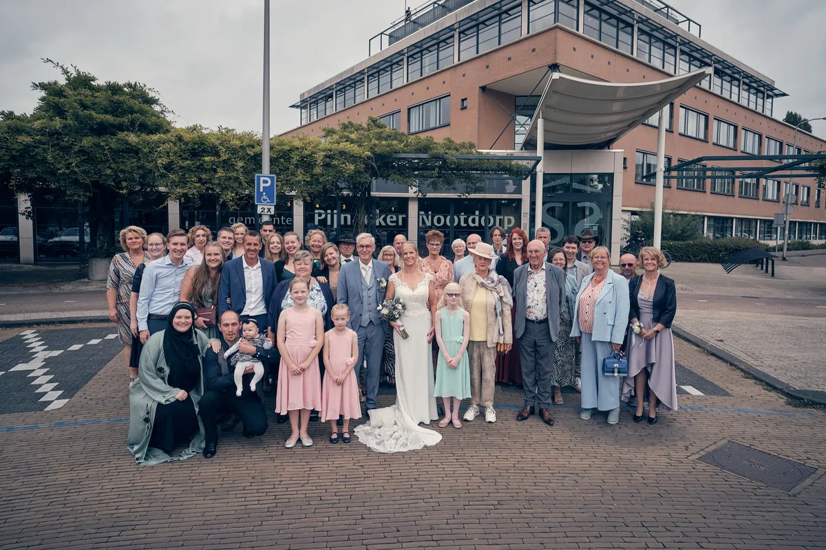 Groepsfoto met alle gasten voor het gemeentehuis