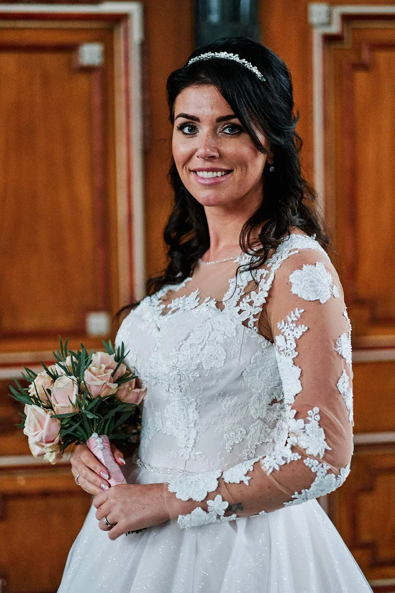 Kimberley met haar boeket voor een oranje houten deur