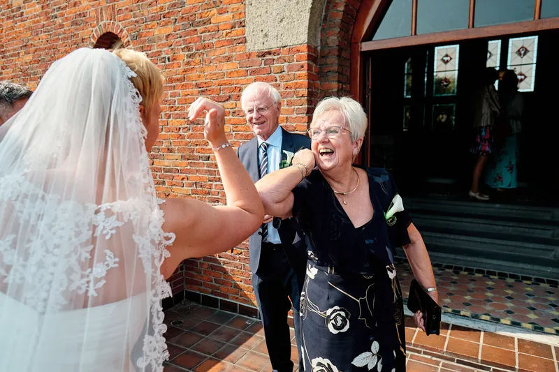 Een gast omhelst Helen bij de deur