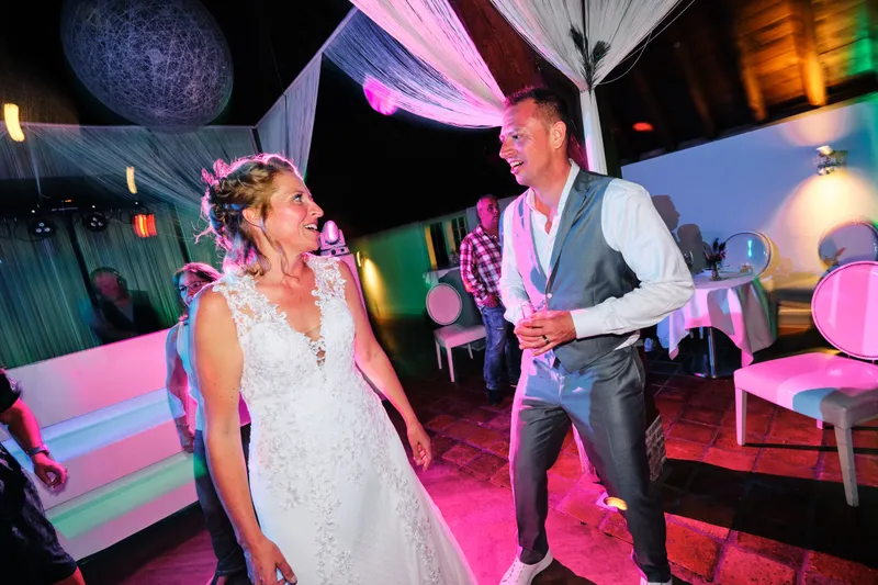 Jilka en Raymond dansen in roze licht op het feest