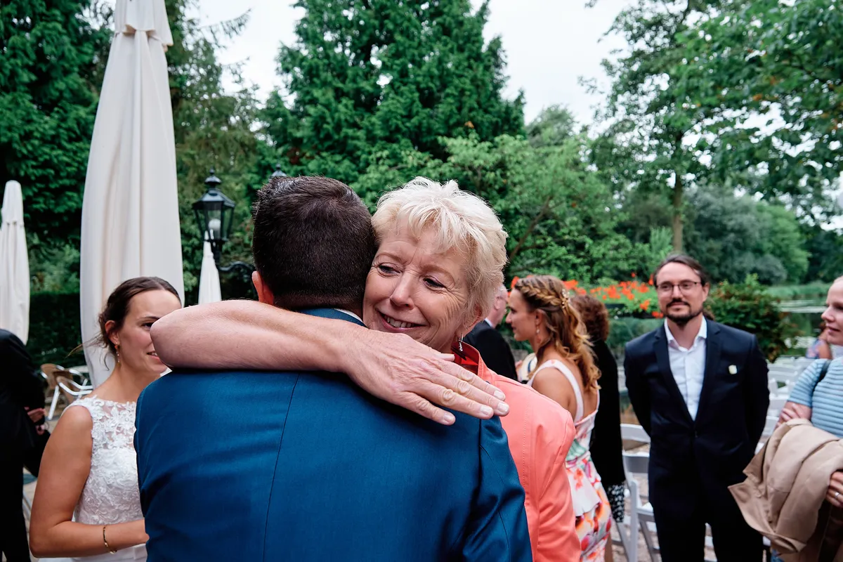 Jeroen krijgt een dikke knuffel van een gast na de ceremonie