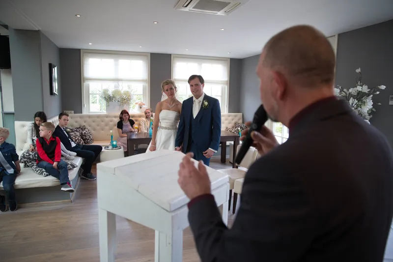 Een gast spreekt het bruidspaar toe
