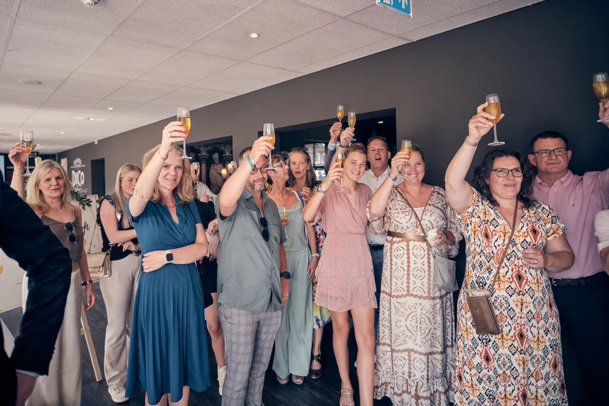 Gasten heffen hun glazen in de zaal