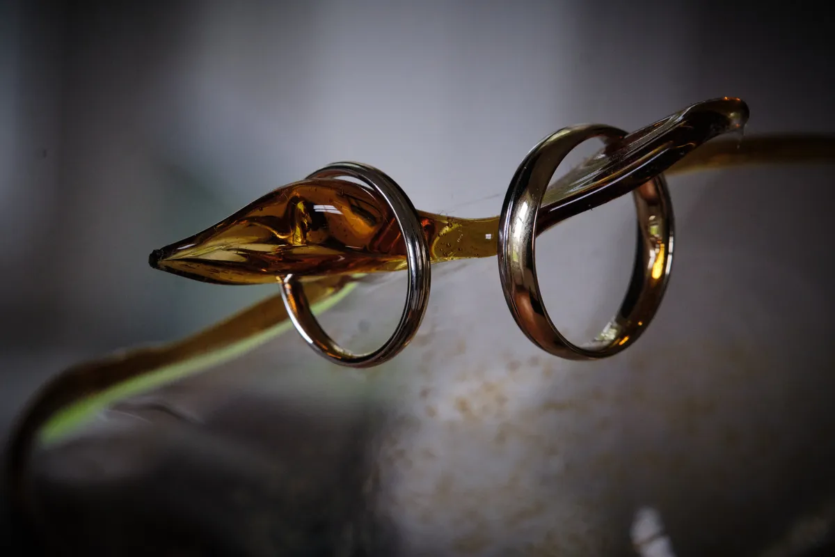 De ringen van Natascha en Tim om een sliert amberkleurig glas van een glazen kunstwerk