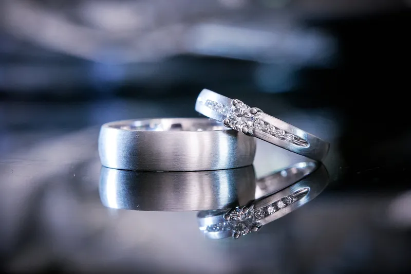 De ringen van Romana en Sander met hun spiegelbeeld op een donkere tafel