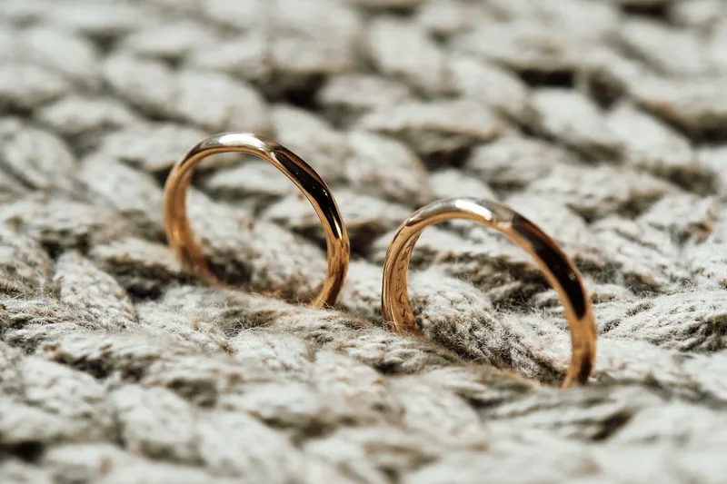 De gouden ringen van Karien en Niels op een stuk touw