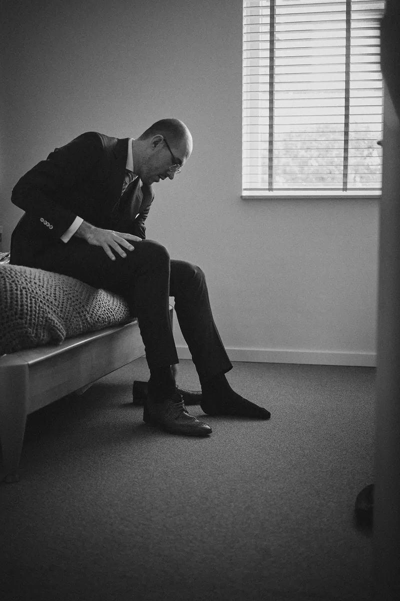 Robbert strikt zijn schoenen op de rand van het bed