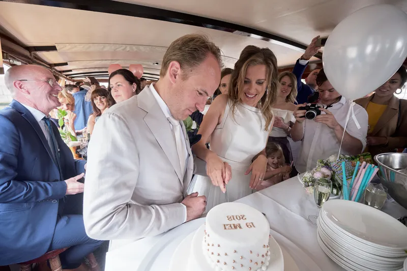 Mary en Jasper snijden de taart aan in de rondvaartboot
