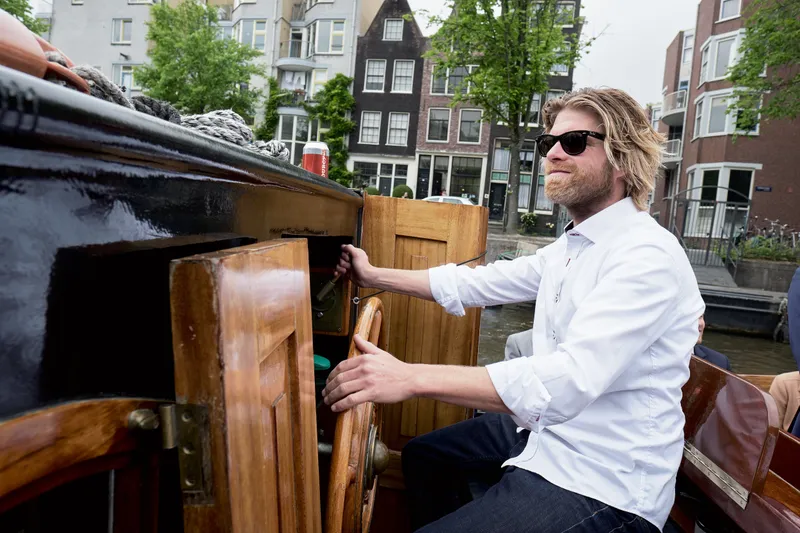Vrienden in de boot, met de grachtenpanden erachter