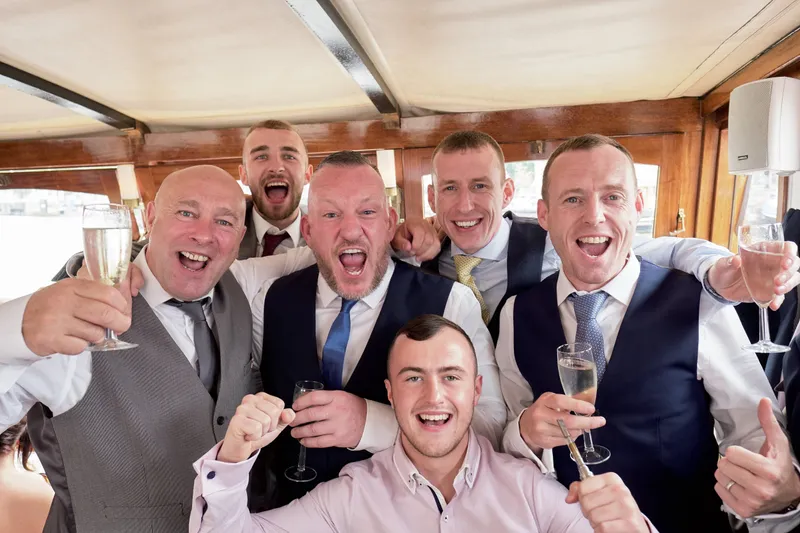 Mannen juichen met champagne in de boot