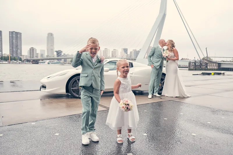 De zoon en dochter van Kim en Dennis op de kade, met de Erasmusbrug erachter