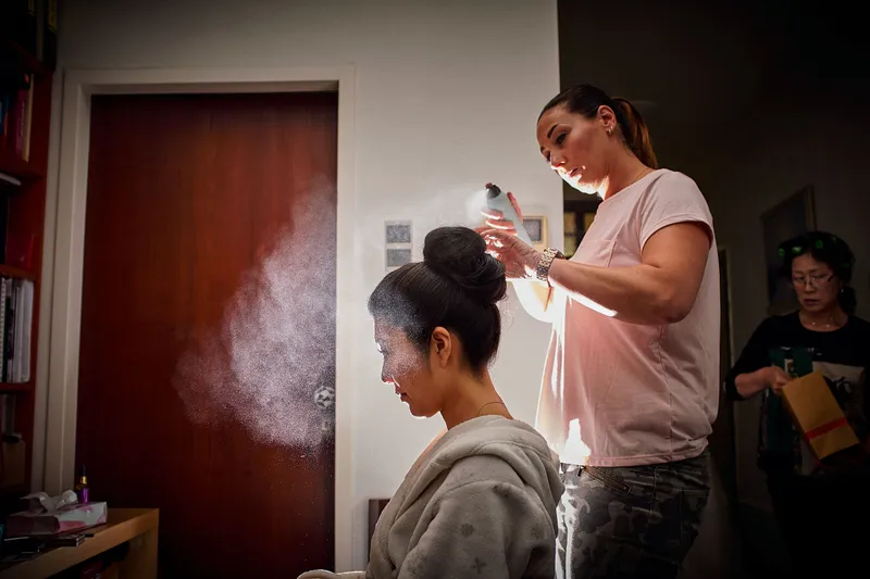 Het haar van Sena wordt opgestoken en vastgezet met haarlak