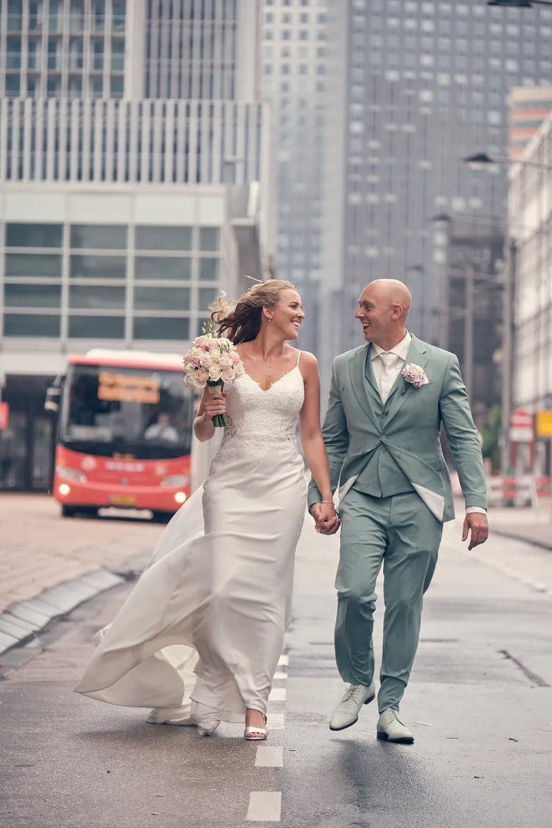 Kim en Dennis lopen over straat tussen de torens, met een rode bus erachter