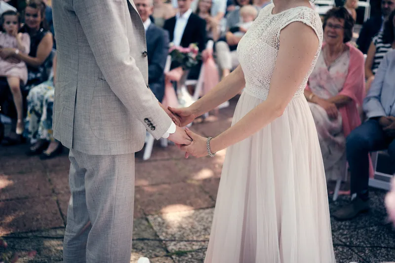 Evelien en Krijn houden elkaars handen vast tijdens de ceremonie