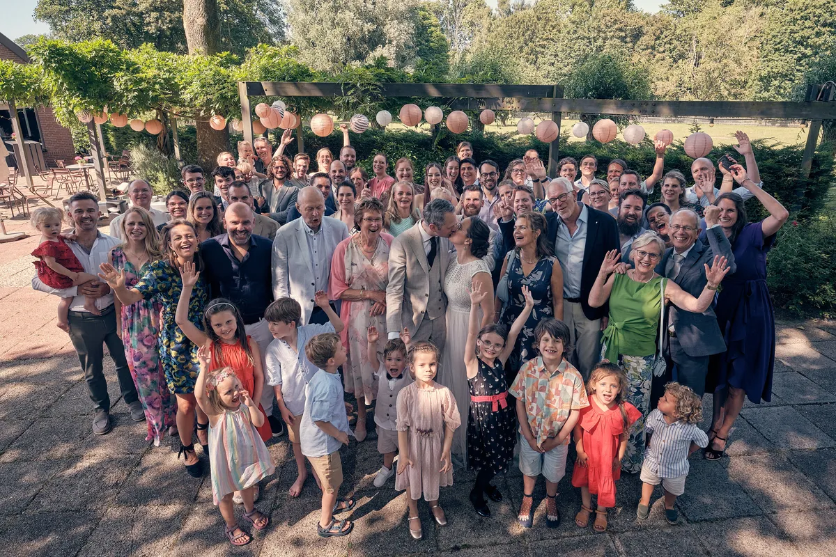 Groepsfoto van alle gasten van bovenaf, op het terras van De Schaapskooi