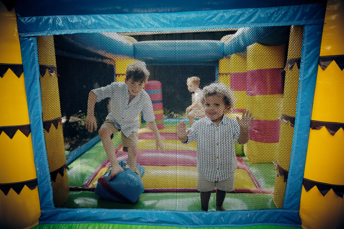 Twee kinderen springen in een kleurrijk springkussen, van bovenaf gefotografeerd
