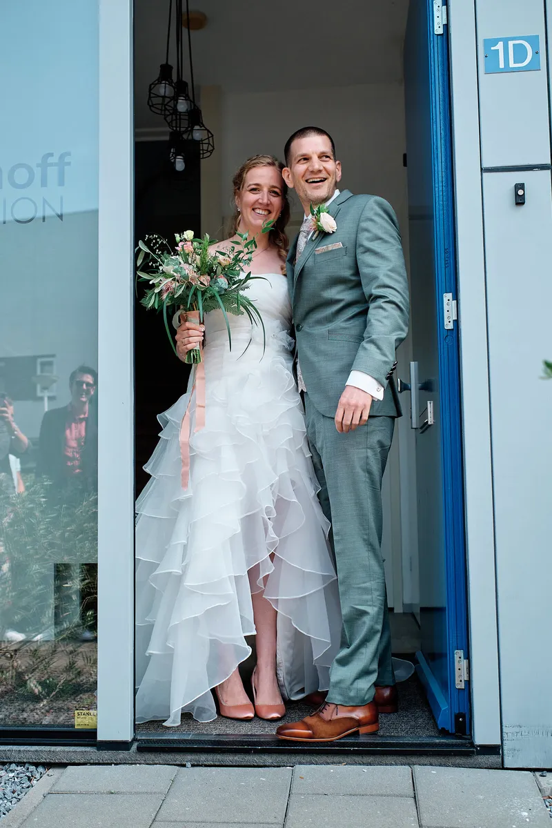 Ylona en Wouter in de deuropening van een blauwe deur