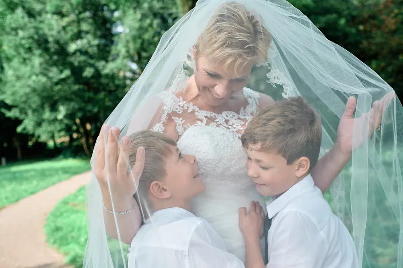 Helen omarmt haar twee zoons onder haar sluier
