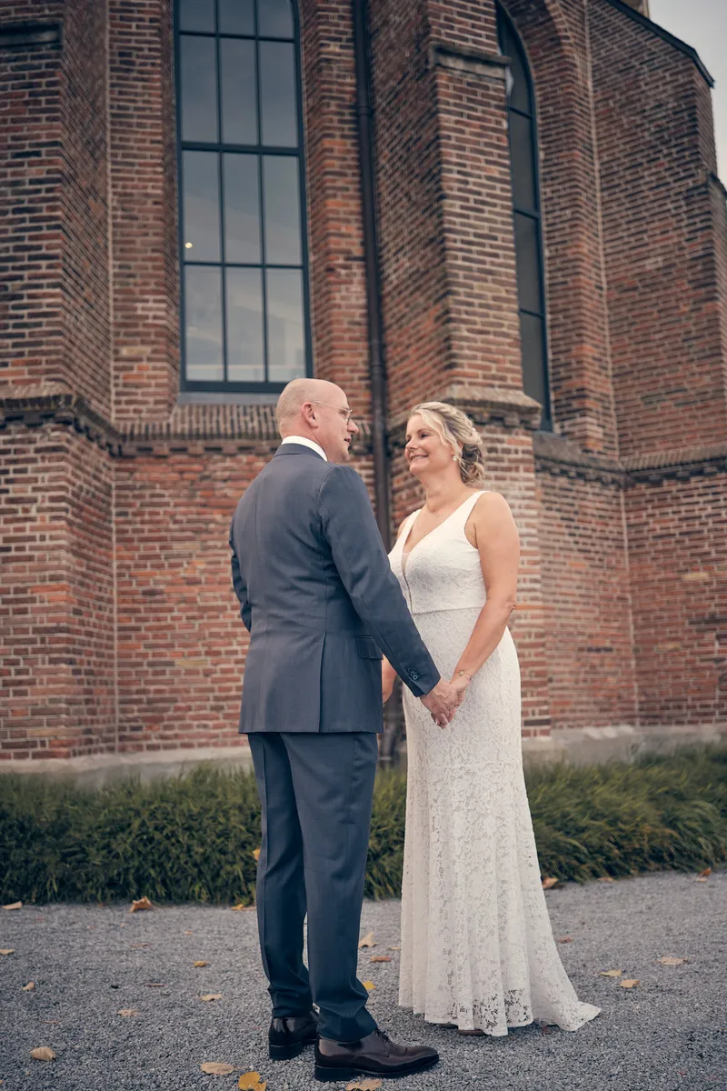 Elles en Bram voor de bakstenen muur van de kerk
