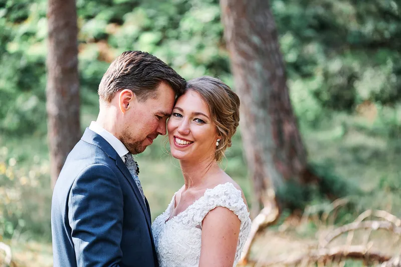 Kirsten en Jouke kijken elkaar lachend aan in het bos